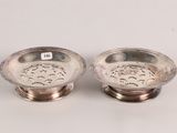 pair of silverplated dishes on stands on a white surface