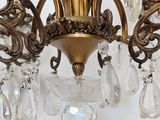 a gold chandelier with crystal drops hanging from it