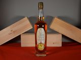 a bottle of whiskey sitting on a table next to two wooden boxes