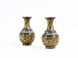 une paire de vases posés sur une surface blanche, avec un fond blanc
