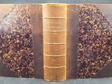un vieux livre à la couverture brune posé sur une table