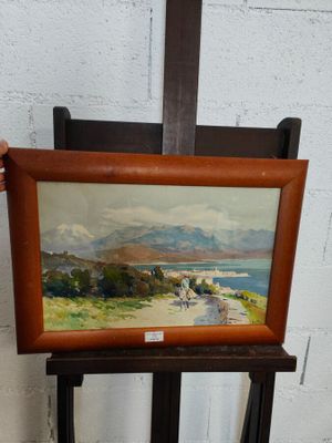 quelqu'un tient un chevalet en bois sur lequel est posé un tableau