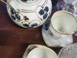 a table with a tea pot, cups, and glasses on it