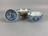 three blue and white bowls with designs on them sitting on a table