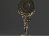 une statue en bronze représentant un homme tenant un bouclier au-dessus de sa tête