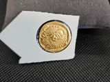 une vieille pièce d'or posée sur un oreiller, à côté d'un autre oreiller
