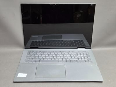 un ordinateur portable posé sur une table, sur une surface blanche
