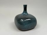 un vase bleu posé sur une table