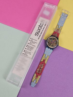 a watch sitting on a colorful surface next to a ruler