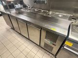 plan de travail en acier inoxydable dans une cuisine professionnelle équipée de trois éviers