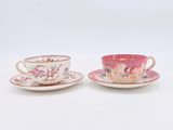 two cups and saucers are sitting side by side on a white surface