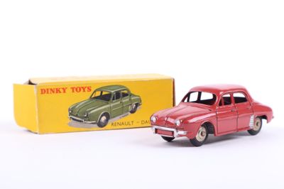 a red toy car in front of a box of dinky toys