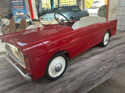 une petite voiture rouge posée sur une table en bois