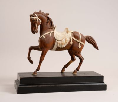 statue of a brown horse with a saddle on a black base