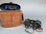 an old pair of binoculars sitting on top of a table next to a case