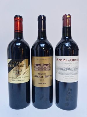 trois bouteilles de vin sont alignées sur une surface blanche