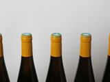 four bottles of wine are lined up in a row on a table