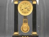 un dôme en verre renfermant une horloge dorée