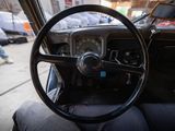 a steering wheel and dashboard of a car on the street