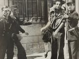 black and white photo of a group of men standing on a sidewalk