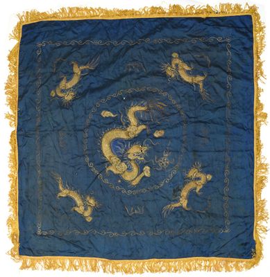 a blue and gold silk table cloth with a dragon design on it