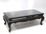 a black coffee table with a glass top on a white background