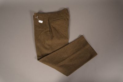 Le pantalon est marron et porte une étiquette blanche.