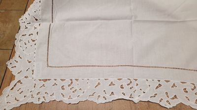 une nappe blanche bordée de dentelle sur la table