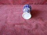 a blue and white vase sitting on a red cloth