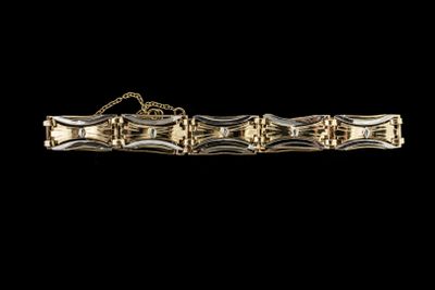 une image montrant un gros plan d'un bracelet en or sur fond noir