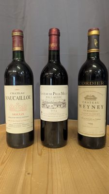 three bottles of wine are lined up on a wooden table
