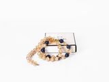 un bracelet en or orné d'une perle bleue et d'une chaîne en or