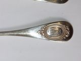 three silver spoons sitting on top of a table next to each other
