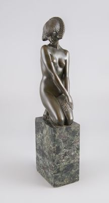 statue d'une femme assise sur un bloc de marbre