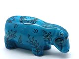 a small blue elephant figurine on a white surface