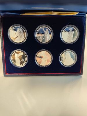 the four coin set is in a blue box on a table