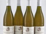 three bottles of white wine are lined up on a table