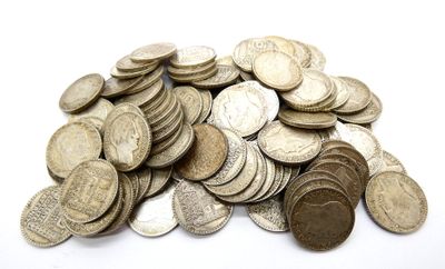 a pile of silver coins on a white surface