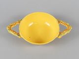 an image of a yellow bowl with handles on a gray surface