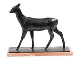 statue d'un cerf posée sur un socle en marbre, sur fond blanc