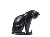 une statue de chat noir posée sur une surface blanche