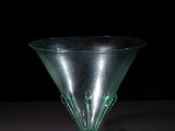 a green glass vase sitting on top of a table