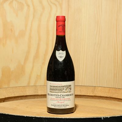 a bottle of wine sitting on top of a barrel