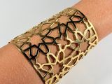 a close up of a person ' s arm wearing a gold bracelet