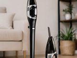 a black and silver vacuum on the floor next to a bottle of champagne