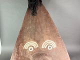 sculpture of a face on a piece of wood on a stand