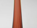 a close up of a red glass vase on a white surface