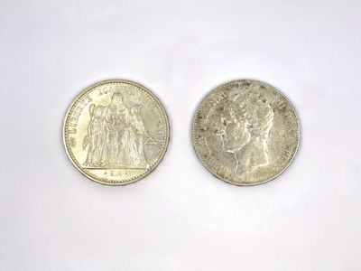 two silver coins sitting next to each other on a white surface