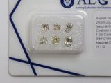 cinq diamants de couleurs différentes présentés dans un emballage posé sur une carte