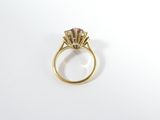 a close up of a gold ring with a pink stone